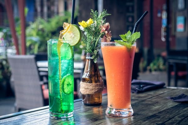 a glass of smoothie and lime juice on table