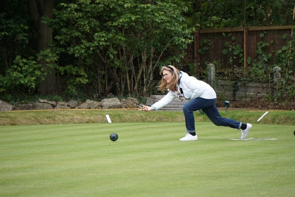 woman playing bocce ball at their backyard