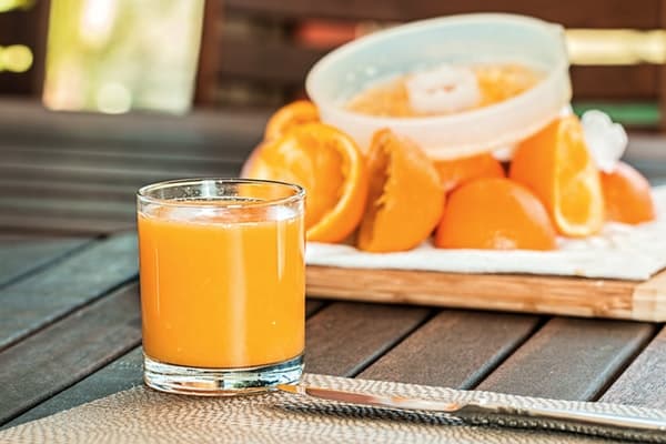 a glass of pure orange juice with its pulp bits